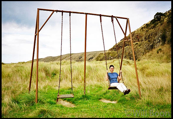 Blandine plays on the swings, Okains Bay, South Island, New Zealand